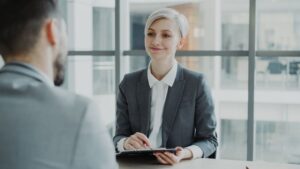 Confident woman interviewing candidate in a modern office. Ideal for business and HR visuals.