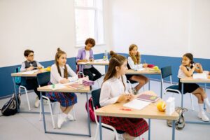 Students learning in a bright, diverse classroom setting, engaged and attentive.